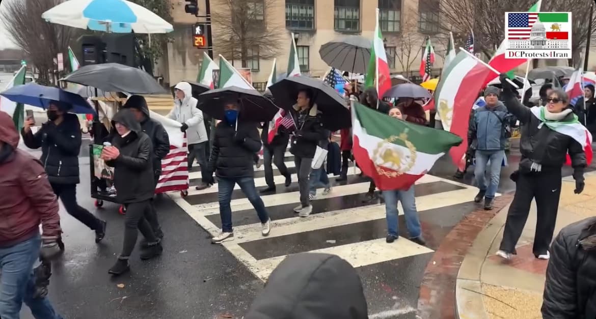 Protesters marching with Iranian and American flags